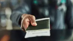 ፓስፖርት የያዘ ሰው እጅ 