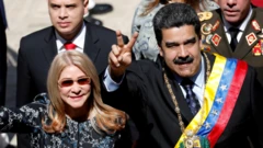 La primera dama de Venezuela, Cilia Flores, saluda junto al presidente de Venezuela, Nicolás Maduro, quien lleva la banda presidencial