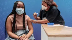 A woman receives a dose of the Pfizer-BioNTech vaccine against Covid-19 in Sandton, Johannesburg, on 15 December 2021