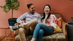 Dos personas conversando sentadas en un sofá