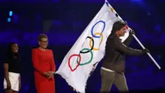 जिम्नास्ट सिमोन बायल्स लॉस एंजेलिस की मेयर कैरेन बास और अभिनेता टॉम क्रूज़ (बाएं से दाएं)