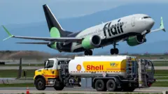 Avión volando sobre un camión cisterna