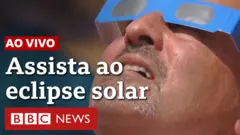Homem observa eclipse solar com óculos especiais