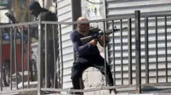 Militante palestino com arma em punho e rosto coberto
