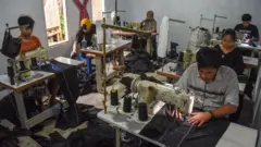 Sejumlah pekerja konveksi menjahit celana gunung dan jaket parasut di rumah produksi Hextstudio, Desa Margahayu, Kecamatan Manonjaya, Kabupaten Tasikmalaya, Jawa Barat, Selasa (13/1/2026).
