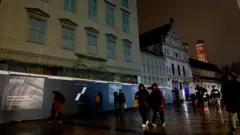 "A segurança da Europa está em construção", diz o slogan estampado em um conjunto chamativo de fotografias em preto e branco, espalhadas por uma igreja coberta de andaimes em uma das mais conhecidas vias para pedestres da cidade