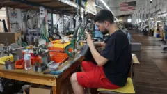 Jared Botelho, empleado de Vanson Leathers, se encarga de la fabricación de los botones a presión para las chaquetas de motociclismo de la empresa.
