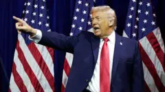 Президент США Дональд Трамп з піднятою рукою на тлі прапорів США