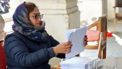 निर्वाचन आयोगमा मतदाता परिचयपत्र तयार पार्दै एक अधिकारी