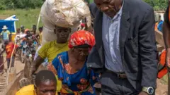 Nin ka mid ah dadka tuulada ayaa ka gudbay buundada alwaax ka sameysan ee laga dhisay wabiga Shange ka dib markii buundada ay ku duntay wadada qaranka ee lambar 5, tuulada Sange, ee gobolka South Kivu, bariga Jamhuuriyadda Dimuqraadiga ah ee Congo, Febraayo 29, 2024.