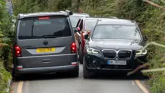 Veículos tentam se espremer entre si nas estreitas faixas da estrada em Porthcurno, na Cornualha, sudoeste da Inglaterra