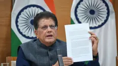 انڈیا کے وزیر تجارت پیوش گوئل پریس کانفرنس کے دوران انڈیا امریکہ تجارتی معاہدے سے متعلق دستاویزات دکھا رہے ہیں
