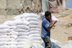 Wani Bafalasdine yana dauke da buhun garin flawa da aka bayar a matsayin taimako ga iyalai a cibiyar rabar da ‘yan gudun hijira ta Majalisar Dinkin Duniya (UNRWA), a sansanin ‘yan gudun hijira na Al-Shati da ke birnin Gaza a ranar 31 ga Yuli, 2023.