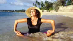 صورة تعود لفبراير من عام 1994 وفيها تمارس الممثلة جوان كولينز التأمل وهي تجلس على حافة المحيط في خليج شوغر في بريدجتاون ببربادوس