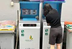 Mulher de costas colocando resíduos em uma máquina branca