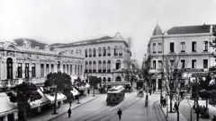 Foto em preto e branco do Largo de São Bento em 1910, com prédios antigos e um bonde passando.