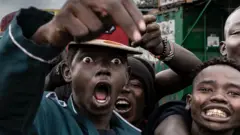 Protesters chanting slogans during a pro-democracy rally on 7 July 2025 in Nairobi, Kenya. Demonstrators answered calls by civil society organisations and other groups to take to the streets. A young man with his mouth wide open chants while surrounded by other young men also chanting.