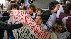 Döviz tutan bir grup şiddetle savruluyor karşısında onları iten eller var. 