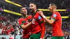 Youssef En-Nesyri (tengah) dan rekan-rekannya merayakan gol ke gawang Portugal dalam babak perempat final Piala Dunia 2022. Berkat golnya, Maroko menjadi tim Afrika pertama yang lolos ke laga semifinal Piala Dunia.