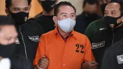Terpidana kasus korupsi pengalihan hak tagih (cessie) Bank Bali Djoko Tjandra (tengah) dibawa petugas Kepolisian saat penandatanganan berita acara penyerahterimaan kepada Kejaksaan Agung di kantor Bareskrim Mabes Polri, Jakarta, Jumat (31/07).