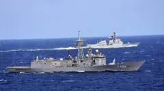 Önde Türk arkada Amerikan bayraklı iki donanma gemisi mavi sularda aynı yönde ilerliyor. 
