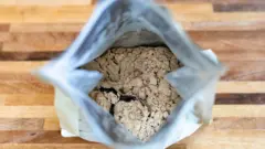 Embalagem de whey protein aberta e vista de cima