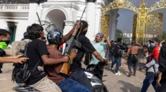 सिंहदरबारअघि लुटिएका हतियार बोकेका प्रदर्शनकारी