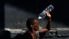 Homem se refresca com garrafajogo stakeágua no Riojogo stakeJaneiro 