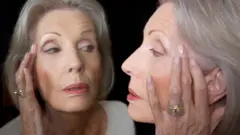 Una mujer mayor mirándose al espejo.