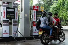 ඉන්ධන පිරවුම්හලක්. යතුරු පැදියකට ඉන්ධන පුරවන තුරු බලා සිටින යුවළක්