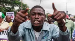 Umugabo uzamuye intoki uri mu bigaragambya