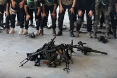 یوه ګواټه وسلې پر ځمکه پراته دي، په داسې حال کې چې د حماس وسلوال لمونځ ادا کوي.
