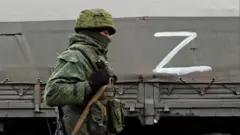 Російський військовий на тлі вантажівки із літерою Z на борту