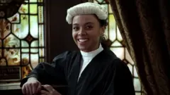 Close up of Alexandra Wilson wearing her wig and gown