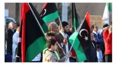 اشخاص يحملون أعلاما ليبية