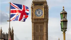 El Big Ben junto a una bandera de Reino Unido.