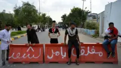 حاجز كتب عليه "مغلق بأمر الشعب" نصبه متظاهرون عراقيون أمام مبنى يضم مكاتب الحكومة في مدينة النجف في الرابع من نوفمبر تشرين الثاني 2019