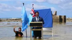 وقف وزير خارجية جزيرة توفالو النائية في المحيط الهادئ ببدلة رسمية وربطة عنق على منبر وسط البحر حيث وصل الماء لفخذه في إشارة لوضع بلده المهدد بالاختفاء بسبب ارتفاع منسوب المياه.