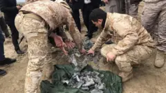Iraqi security forces gather pieces of Iranian missile in Irbil