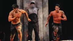 Two contestants dash to catch a ball which they have to secure for three minutes