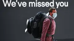 Man walks in front of a sign saying we've missed you
