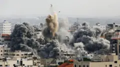 Moshi ukifuka juu ya nyumba huku mashambulizi ya angani ya Israeli yakiendelea katika mji wa Gaza Oktoba 9, 2023.