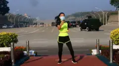 Khing Hnin Wai dança com veículos militares ao fundo