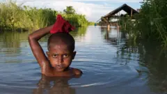 Boy standing in floodwater in Bangladesh