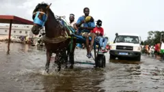Une charrête assurant le transport sur une route inondée à Dakar