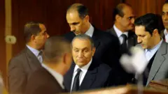 حسني مبارك في الوسط، مع ابنيه علاء (على اليمين) وجمال (على اليسار)