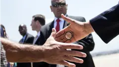 Mano presidencial con una moneda.