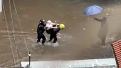 Maria Ladi Rodrigues, de 77 anos, sendo resgatada por motoboys