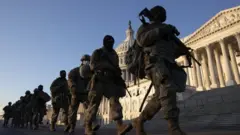 Soldiers walk in a line outside the US Capitol