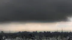 Horizonte em São Paulo com prédios e mancha de poluição no céu